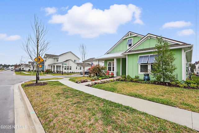 view of front of property with driveway, board and batten siding, a front yard, and a residential view