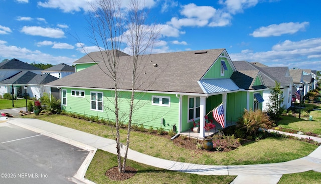 view of property exterior with a yard, roof with shingles, board and batten siding, and a residential view