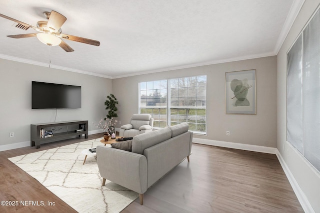 living area featuring crown molding, wood finished floors, and baseboards