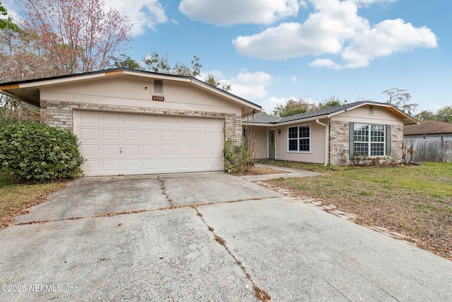 ranch-style home featuring a front lawn, concrete driveway, a garage, and fence