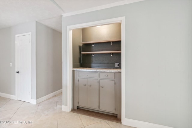 bar with light tile patterned floors and baseboards