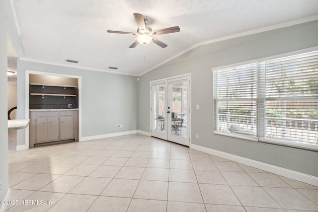 interior space with ornamental molding, a ceiling fan, french doors, light tile patterned floors, and vaulted ceiling