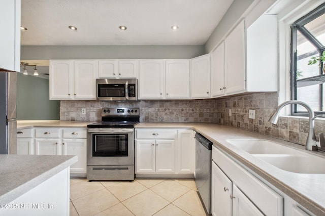 kitchen featuring a sink, tasteful backsplash, stainless steel appliances, light countertops, and light tile patterned floors