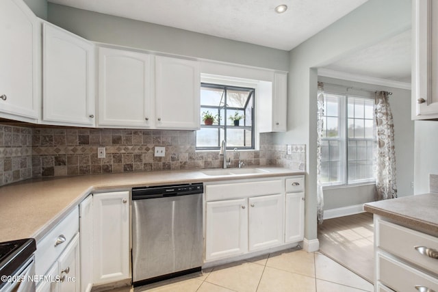 kitchen with decorative backsplash, appliances with stainless steel finishes, light tile patterned flooring, white cabinets, and a sink