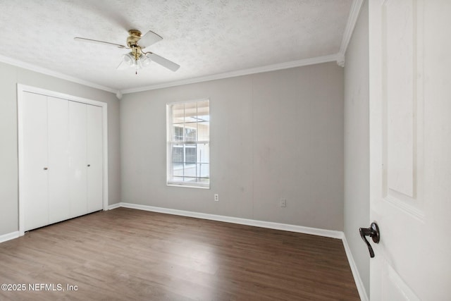 unfurnished bedroom featuring a closet, a textured ceiling, wood finished floors, and crown molding