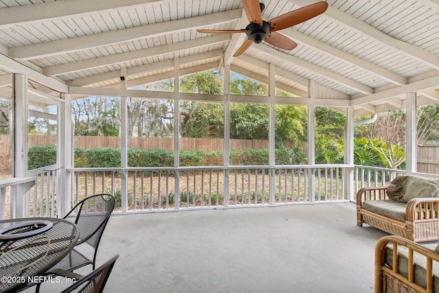 sunroom with lofted ceiling with beams and ceiling fan