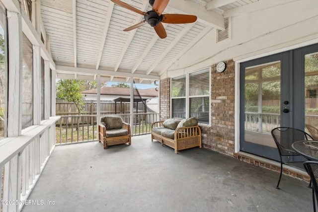 sunroom with lofted ceiling with beams and ceiling fan