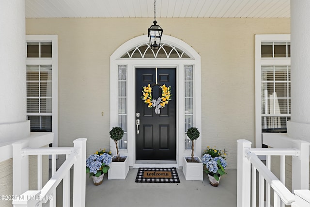 doorway to property featuring stucco siding