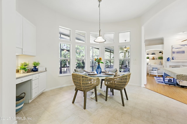 dining space with a ceiling fan, baseboards, and a healthy amount of sunlight