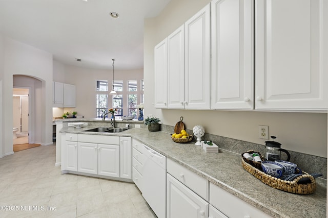 kitchen featuring dishwasher, arched walkways, white cabinetry, and a sink