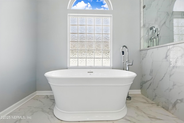 bathroom featuring a marble finish shower, a freestanding tub, baseboards, and marble finish floor