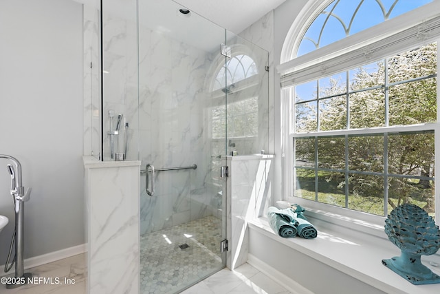 full bathroom featuring a wealth of natural light, marble finish floor, a garden tub, and a marble finish shower