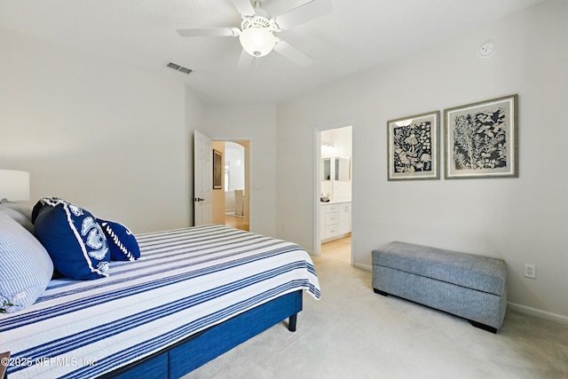 bedroom featuring visible vents, light colored carpet, ensuite bathroom, and a ceiling fan