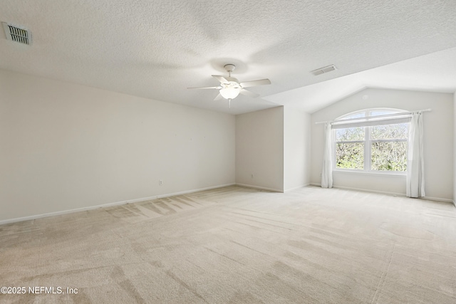 unfurnished room with visible vents, light carpet, ceiling fan, and vaulted ceiling