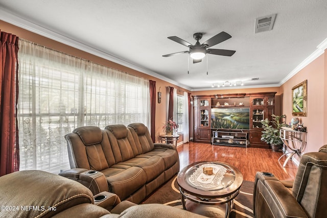 living area featuring visible vents, ceiling fan, wood finished floors, a textured ceiling, and crown molding