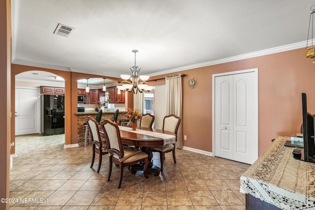 dining area featuring ornamental molding, arched walkways, visible vents, and an inviting chandelier