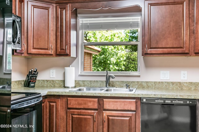 kitchen with light countertops, a sink, and black appliances