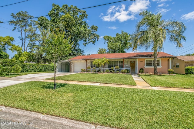 single story home with concrete driveway, an attached garage, a front yard, a carport, and stucco siding