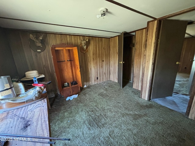 bedroom with dark colored carpet and wood walls