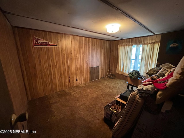 living area featuring wooden walls and carpet flooring