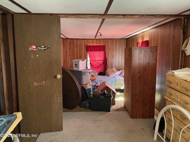 carpeted bedroom featuring wood walls