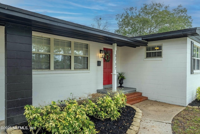 doorway to property with concrete block siding