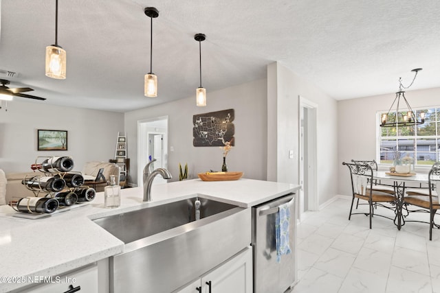 kitchen with a textured ceiling, open floor plan, marble finish floor, dishwasher, and decorative light fixtures