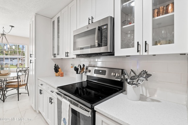 kitchen featuring appliances with stainless steel finishes, marble finish floor, and white cabinets