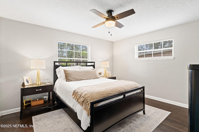 bedroom featuring a ceiling fan, a textured ceiling, baseboards, and wood finished floors