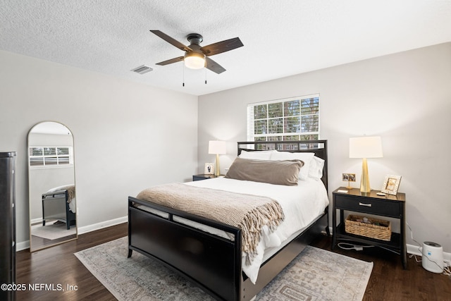 bedroom with ceiling fan, a textured ceiling, baseboards, and wood finished floors