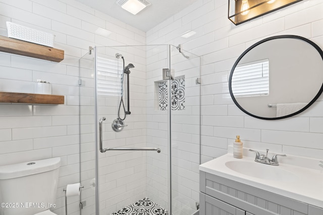 bathroom featuring a shower stall, visible vents, tile walls, and vanity