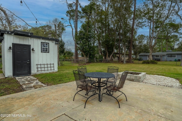 view of patio / terrace with fence, an outbuilding, and outdoor dining space