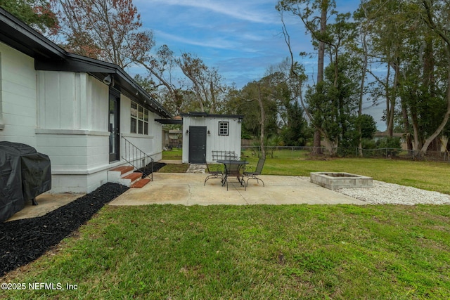 view of yard featuring entry steps, a patio, an outdoor fire pit, and a fenced backyard