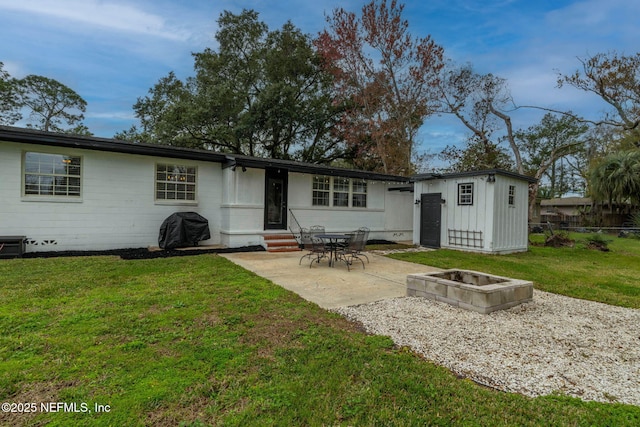 back of property with entry steps, a patio, an outdoor fire pit, a yard, and board and batten siding