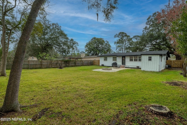 view of yard featuring a patio area, an outdoor fire pit, a fenced backyard, and an outdoor structure