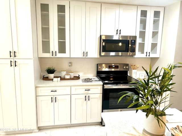 kitchen featuring tasteful backsplash, stainless steel appliances, and white cabinets