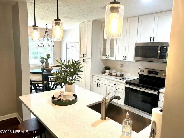 kitchen with a sink, white cabinets, and appliances with stainless steel finishes