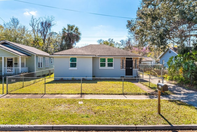 view of front of property featuring a shingled roof, a fenced front yard, a front lawn, and stucco siding