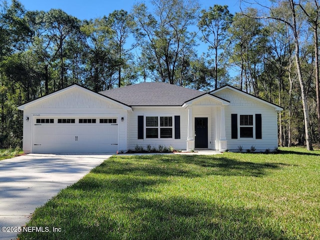 11140 Pine Estates Rd W, Jacksonville, FL 32218 - view of front facade featuring a garage, concrete driveway, roof with shingles, board and batten siding, and a front yard