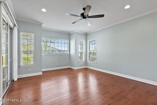 spare room featuring dark wood-style floors, ornamental molding, a textured ceiling, and baseboards