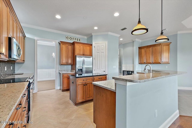 kitchen with brown cabinetry, appliances with stainless steel finishes, pendant lighting, and light stone counters