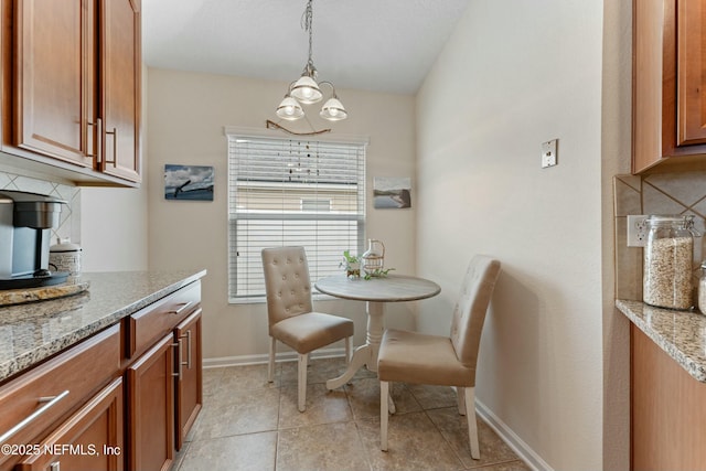 dining room featuring light tile patterned floors, baseboards, and an inviting chandelier