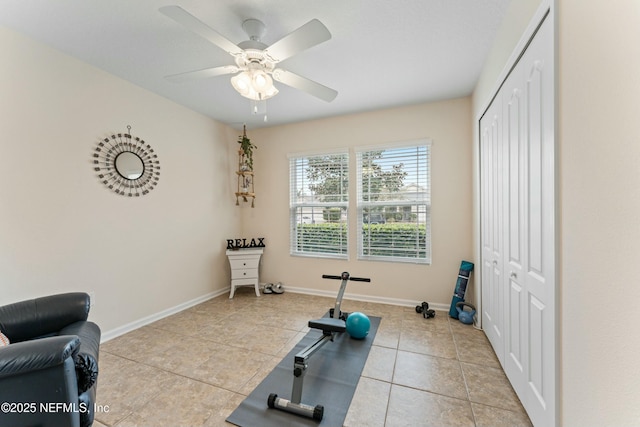 exercise area with light tile patterned floors, ceiling fan, and baseboards