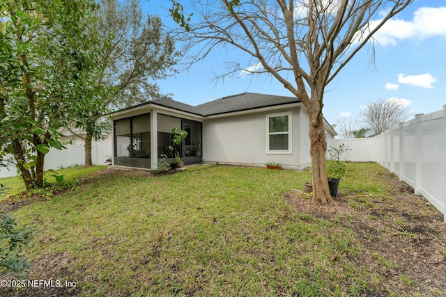 rear view of property featuring a sunroom, a fenced backyard, and a lawn