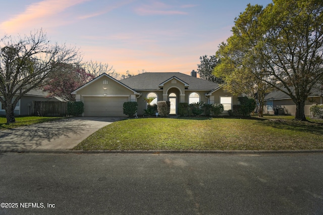 ranch-style home featuring concrete driveway, a chimney, an attached garage, fence, and a front lawn