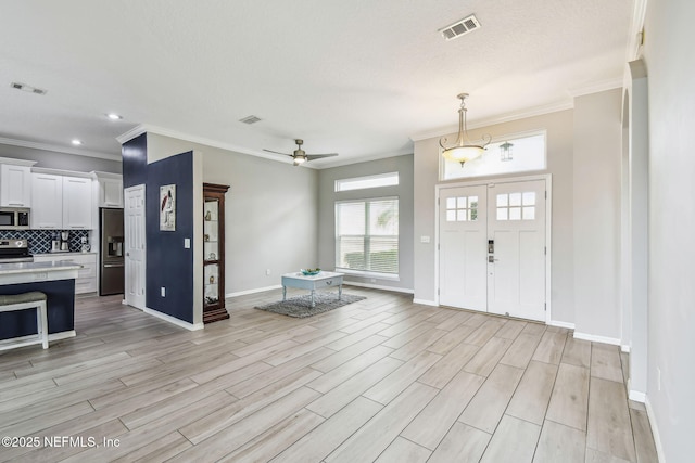 entryway with light wood-type flooring, baseboards, and visible vents