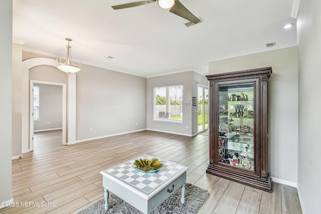 living room with wood tiled floor, a textured ceiling, arched walkways, and baseboards