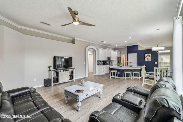 living area featuring arched walkways, visible vents, wood tiled floor, a textured ceiling, and ceiling fan with notable chandelier