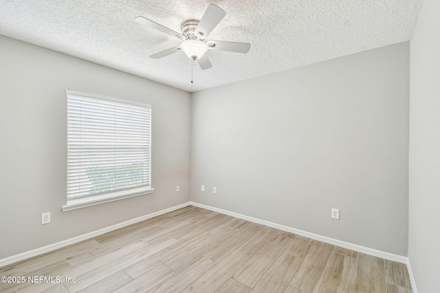 spare room with ceiling fan, a textured ceiling, baseboards, and wood finished floors