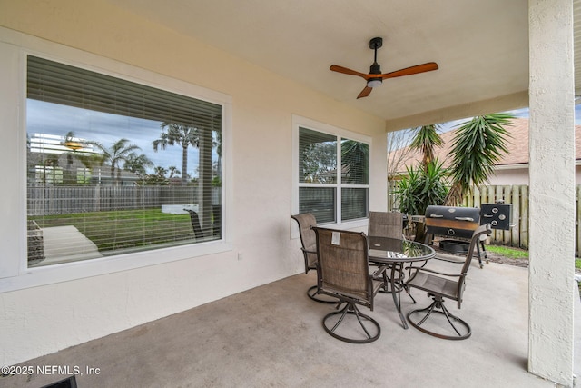 view of patio with outdoor dining area, grilling area, fence, and a ceiling fan